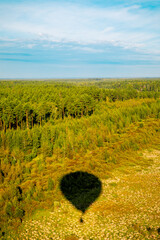 silhouette, shadow of air balloon flying over yellow wheat field