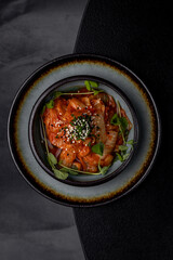 Cabbage kimchi on a plate in a restaurant on a dark background