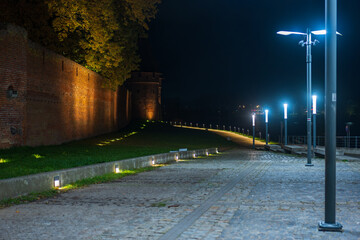 Malbork Castle red brick walls and tower by the Nogat at night