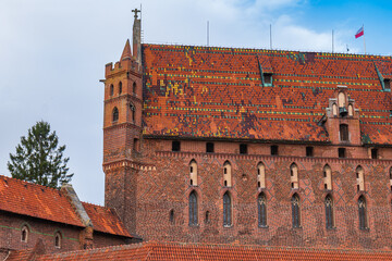 Obraz premium Malbork Castle bastion and lancet windows with tiled roof, Poland
