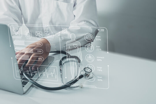 Healthcare and technology concept. Doctor at desk with stethoscope and laptop showing holographic medical chart. Future of medicine, data analytics,patient care on white background with copyspace.
