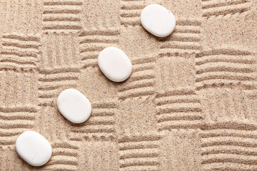 White stones on sand with pattern. Zen concept