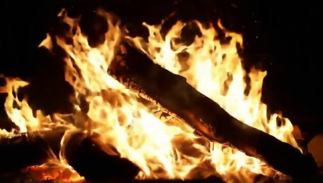 Close-up of a burning wooden log with intense orange flames, glowing sparks, and dark smoky background, high contrast.
