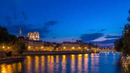 Fototapeta premium Le Pont D'Arcole bridge after sunset with people and boats day to night timelapse, Paris, France, Europe