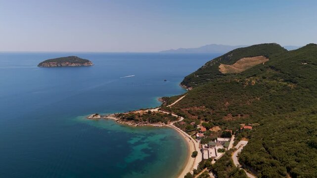 High altitude aerial drone approach to the uninhabited Fidonisi Island over the turquoise Thracian Sea with Thasos visible on the distant horizon, Greece.