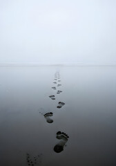 Reflective footprints on wet beach
