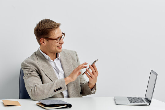 smiling caucasian man working digital nomad using smartphone laptop indoor communication technology concept