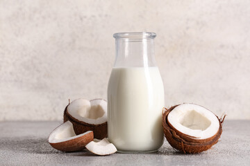 Bottle of tasty fresh coconut milk on grunge background, closeup