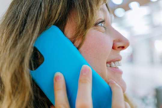 Smiling woman talking on a smartphone, enjoying a conversation and expressing positive emotions while communicating digitally, representing modern connectivity