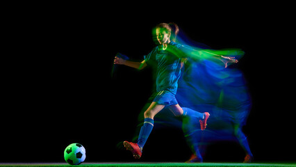 Obraz premium Female soccer player kicking ball in glowing teal and green motion blur. Concept of energy, body in motion, sport performance visuals, fitness campaigns, and brand promotion.