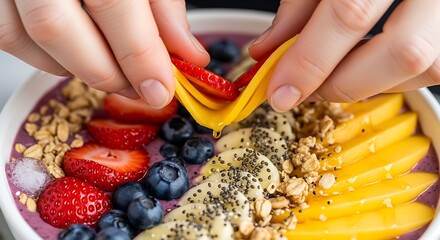 Preparing vibrant smoothie bowl with fresh fruits and granola toppings