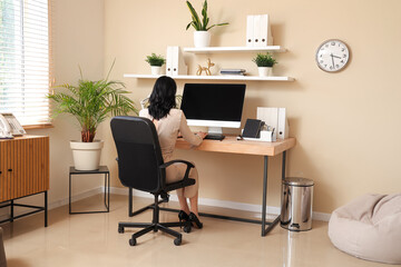 Young woman working with modern computer at workplace in stylish office
