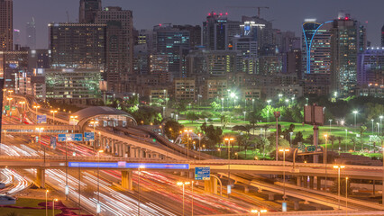 Obraz premium Dubai Golf Course with a cityscape of Greens and tecom districts at the background aerial day to night timelapse