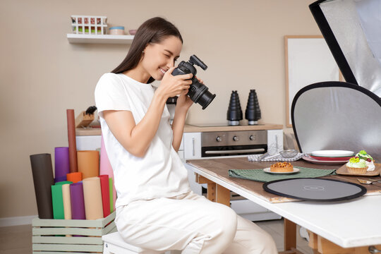 Young female food photographer with professional equipment taking pictures of dessert in kitchen - Powered by Adobe