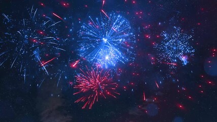 Bright Christmas and New Year celebration fireworks light the night sky with stars. Red and Blue Fireworks Display at Night Video Clip. - Powered by Adobe
