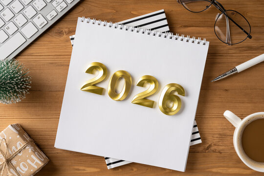A desk scene for year end and holiday plans with a 2026 calendar, gift, coffee, and office items suggesting Christmas and New Year greetings - Powered by Adobe