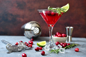 Cranberry martini cocktail with rosemary in a  glass .