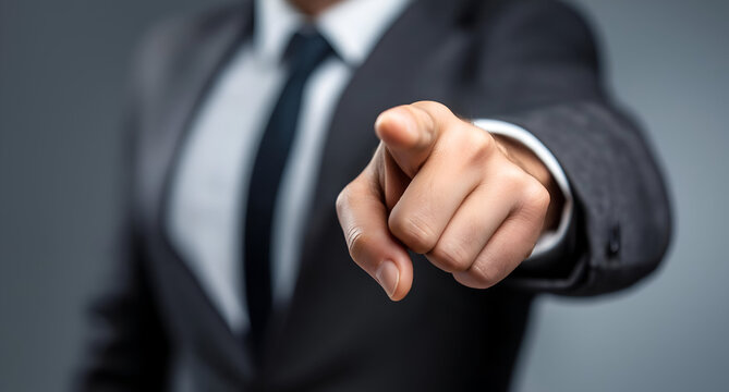 An assertive business professional points forward, exuding confidence and leadership in a modern setting.