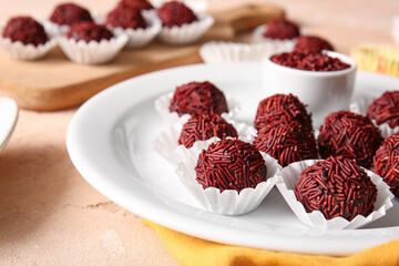 Plate with chocolate truffles in paper cups, closeup