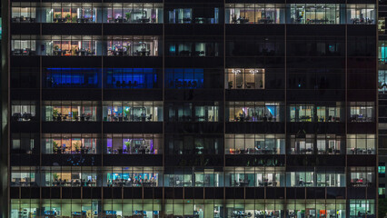 Modern office building with big windows at night timelapse, in windows light shines