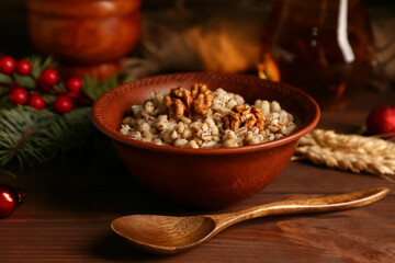 Bowl of traditional Ukrainian Kutya dish and Christmas tree branch on wooden background