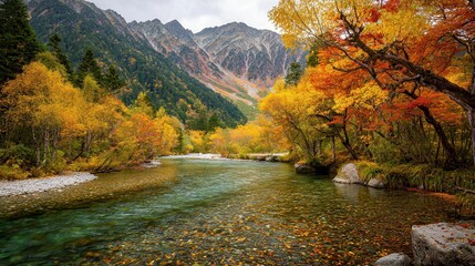 Obraz premium Stunning fall hues cover the tranquil Kamikochi Valley in the Japanese Alps The image depicts a vivid scene with golden and red foliage contrasting beautifully with the backgro