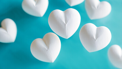 Obraz premium white plush heart shapes floating on turquoise background
