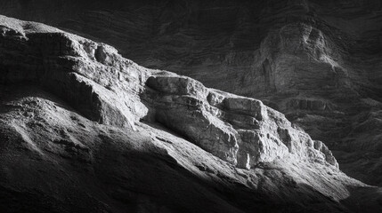 Striking monochrome landscape featuring rocky mountainside textures bathed in light and shadow. Powerful, timeless feel. Ideal for nature, travel, or abstract design.