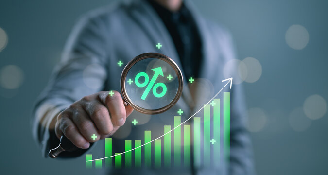 Businessman analyzing growth with magnifying glass showing upward graph and percentage symbol, representing ROI increase, financial success, investment performance, and economic growth.