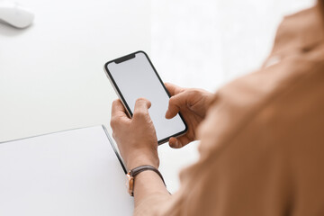 Young businesswoman using blank mobile phone in office, closeup