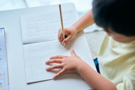 家で漢字の練習をする小学生の男の子