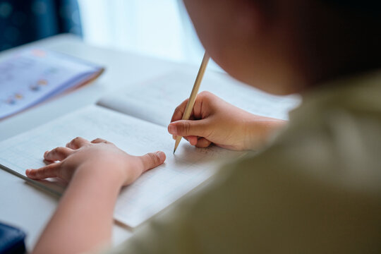 家で漢字の練習をする小学生の男の子