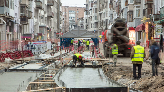 Concrete works for road maintenance construction site with many workers and mixer timelapse