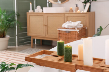 Burning candles on tray in bathroom, closeup