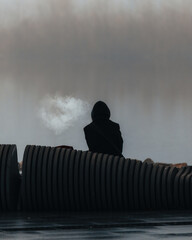 A close-up that emphasizes the visual contrast between the black, indistinguishable hooded figure...