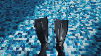 Image of an individual in black swim fins in a pool with blue tiles representing summer and aquatic activities