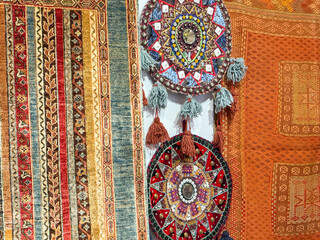 Istanbul, Turkey - August 28, 2025: Traditional Turkish carpets and round embroidered wall decorations displayed outside a rug store in Istanbul