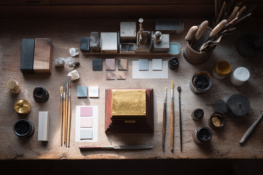 Artisans workspace with tools, paint, and a wooden plaque. Concept for craft, creativity, and detailed handwork. Use for design, hobbies or artistic endeavors. - Powered by Adobe