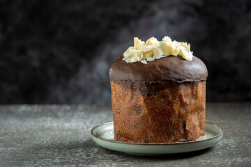 Gourmet Panettone with Dark Chocolate Glaze and White Chocolate Shavings on Dark Background