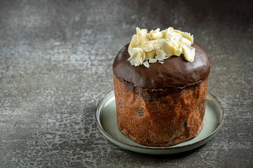 Gourmet Panettone with Dark Chocolate Glaze and White Chocolate Shavings on Dark Background