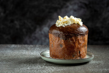 Gourmet Panettone with Dark Chocolate Glaze and White Chocolate Shavings on Dark Background