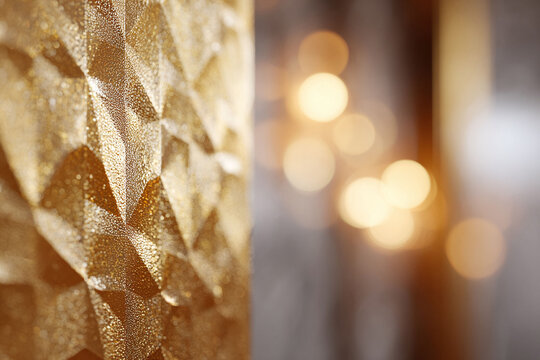 Golden textured surface against a bokeh background.  Evokes luxury, warmth, and celebration.  Ideal for designs needing a touch of elegance and festive spirit.