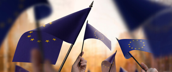 European Union flags in their hands on a blurred urban background © butenkow