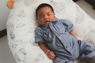 Cute newborn baby boy sleeping peacefully in white crib and soft nest. Close-up of infant resting on bed, symbolizing childhood innocence, comfort, and family love. Perfect for baby care themes.