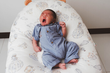 Cute newborn baby boy sleeping peacefully in white crib and soft nest. Close-up of infant resting on bed, symbolizing childhood innocence, comfort, and family love. Perfect for baby care themes.