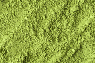 Detailed close-up of vibrant green matcha powder reveals rough uneven texture and organic surface perfect for food backgrounds. © SOLDATOOFF