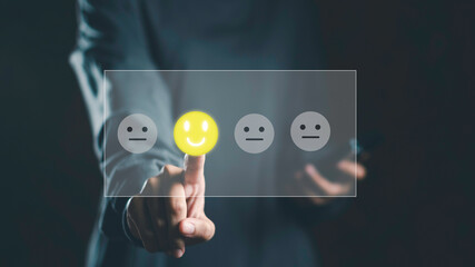 Feedback and digital survey concept with user selecting happy face emoji on virtual screen. Represents customer satisfaction, experience rating, and interactive opinion collection in real time.