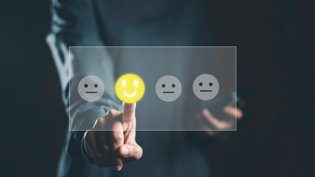 Feedback and digital survey concept with user selecting happy face emoji on virtual screen. Represents customer satisfaction, experience rating, and interactive opinion collection in real time.