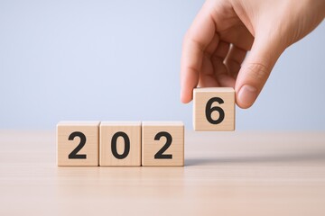 Anticipating the Future: Hand Placing Number Block to Symbolize the Year 2026 with Optimistic Outlook