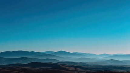 Serene Mountain Landscape with Soft Blue Skies and Layered Hills in the Distance Captured at Dawn, Emanating Peace and Natural Beauty